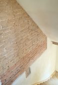 Treppenhaus mit Lehm-Edelputz und restaurierter Backstein-/Lehmsteinwand